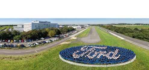700 Mitarbeiter von Ford in Köln stellen sich bei einer Veranstaltung als Logo für ein Luftbild auf